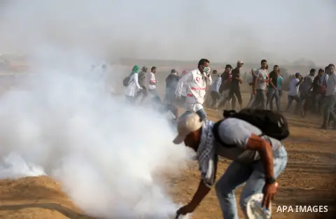 Palestinian protesters gather during clashes with Israeli troops in tents protest where Palestinian demand the right to return to their homeland at the Israel-Gaza border, in Khan Younis, in the southern Gaza Strip on Au...