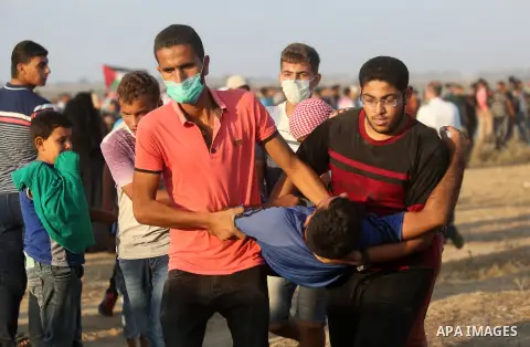 Palestinian protesters gather during clashes with Israeli troops in tents protest where Palestinian demand the right to return to their homeland at the Israel-Gaza border, in Khan Younis, in the southern Gaza Strip on Au...