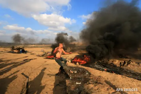 Palestinian protesters gather during clashes with Israeli troops in tents protest where Palestinian demand the right to return to their homeland at the Israel-Gaza border, in al-Bureij, in the center of Gaza Strip on Aug...