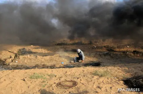 Palestinian protesters gather during clashes with Israeli troops in tents protest where Palestinian demand the right to return to their homeland at the Israel-Gaza border, in al-Bureij, in the center of Gaza Strip on Aug...