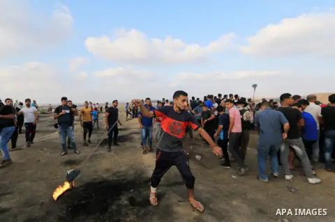 Palestinian protesters gather during clashes with Israeli troops in tents protest where Palestinian demand the right to return to their homeland at the Israel-Gaza border, in al-Bureij, in the center of Gaza Strip on Aug...