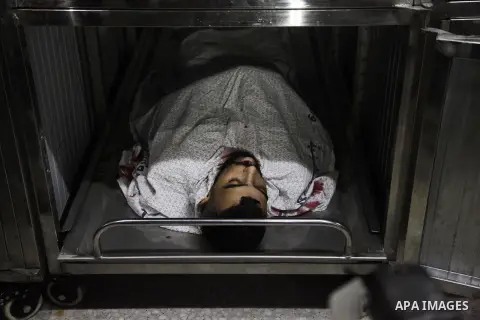 Relatives of Palestinian Ahmed Yaghi, 25, who was shot dead by Israeli troops during clashes at Gaza-Israel border mourn over his body at a morgue in a hospital in Gaza city on Aug. 03, 2018. Photo by Mahmoud Ajour