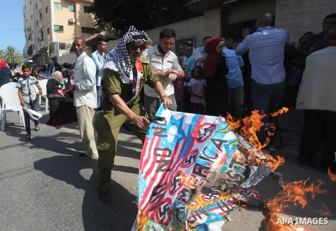 Palestinians burn an Israeli, British and U.S. flags during a protest to show solidarity with Palestinian prisoners held in Israeli jails, in front of Red cross office in Gaza city on August 6, 2018. Photo by Mahmoud Ajo...