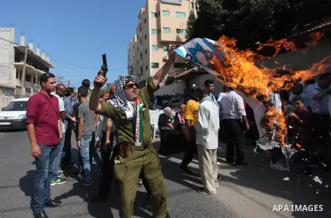 Palestinians burn an Israeli, British and U.S. flags during a protest to show solidarity with Palestinian prisoners held in Israeli jails, in front of Red cross office in Gaza city on August 6, 2018. Photo by Mahmoud Ajo...