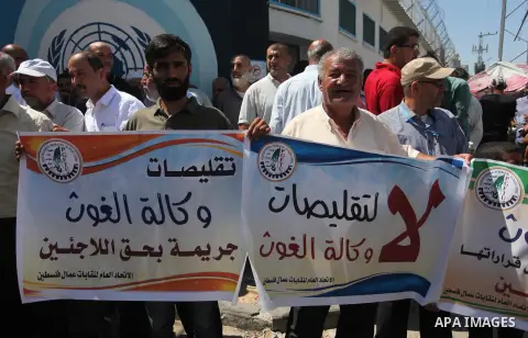 Palestinians hold banners during a protest against a U.S. decision to cut aid, in front of the headquarters United Nations Relief and Works Agency (UNRWA), in Gaza City, on August 6, 2018. Photo by Mahmoud Ajour