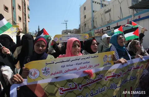 Palestinians hold banners during a protest against a U.S. decision to cut aid, in front of the headquarters United Nations Relief and Works Agency (UNRWA), in Gaza City, on August 6, 2018. Photo by Mahmoud Ajour