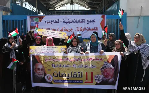 Palestinians hold banners during a protest against a U.S. decision to cut aid, in front of the headquarters United Nations Relief and Works Agency (UNRWA), in Gaza City, on August 6, 2018. Photo by Mahmoud Ajour