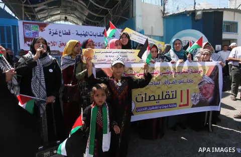 Palestinians hold banners during a protest against a U.S. decision to cut aid, in front of the headquarters United Nations Relief and Works Agency (UNRWA), in Gaza City, on August 6, 2018. Photo by Mahmoud Ajour