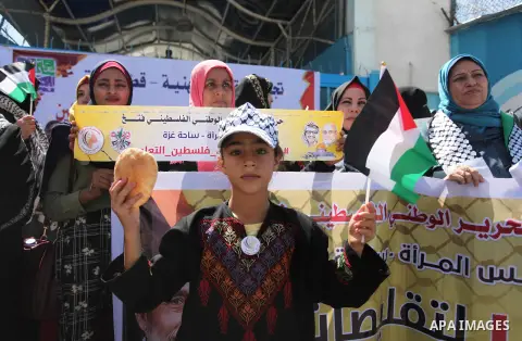 Palestinians hold banners during a protest against a U.S. decision to cut aid, in front of the headquarters United Nations Relief and Works Agency (UNRWA), in Gaza City, on August 6, 2018. Photo by Mahmoud Ajour