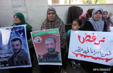 Palestinians take part in a protest to show solidarity with Palestinian prisoners are paid their salaries in Israeli jails in front of the Council of Ministers headquarter in Gaza City, on August 7, 2018. Photo by Mahmou...