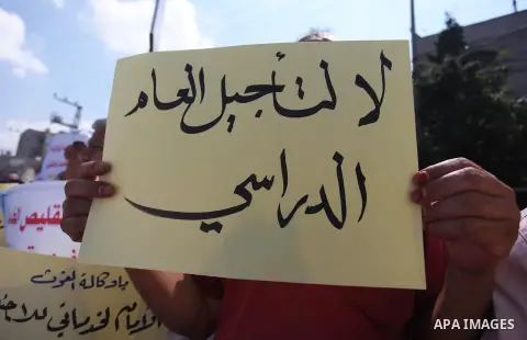 Palestinians hold banners during a protest against a U.S. decision to cut aid in Jabalia in the northern of Gaza Strip on August 7, 2018. Photo by Mahmoud Ajour