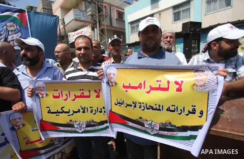 Palestinians hold banners during a protest against a U.S. decision to cut aid in Jabalia in the northern of Gaza Strip on August 7, 2018. Photo by Mahmoud Ajour