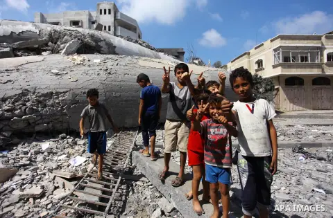 Palestinian children play on the rubble of Said al-Mishal Cultural Center which was destroyed by an Israeli air strike in Gaza city on Aug. 11, 2018. Photo by Mahmoud Ajour