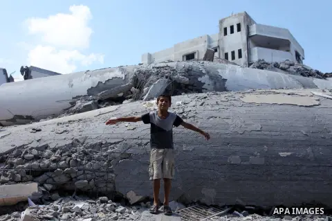 A Palestinian boy stands on the rubble of Said al-Mishal Cultural Center which was destroyed by an Israeli air strike in Gaza city on Aug. 11, 2018. Photo by Mahmoud Ajour