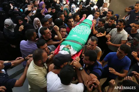 Mourners carry the body of Palestinian Wissam Hijazi, who died of wounds he sustained during clashes with Israeli troops, during his funeral, in Khan Younis in the southern of Gaza Strip on August 13, 2018. Photo by Ashr...