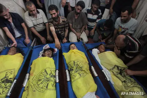 (FILES) This file photo taken on July 16, 2014 shows Palestinians mourn over the body of boys from the Baker family, whom medics said was killed with three other children from the same family by a shell fired by an Israe...