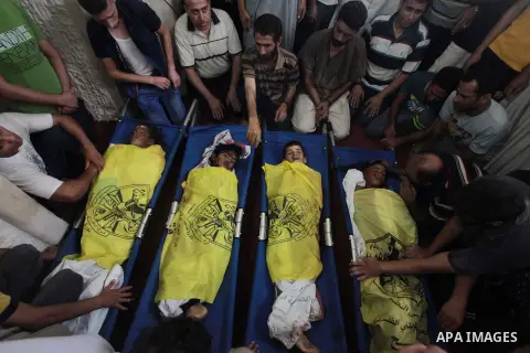 (FILES) This file photo taken on July 16, 2014 shows Palestinians mourn over the body of boys from the Baker family, whom medics said was killed with three other children from the same family by a shell fired by an Israe...