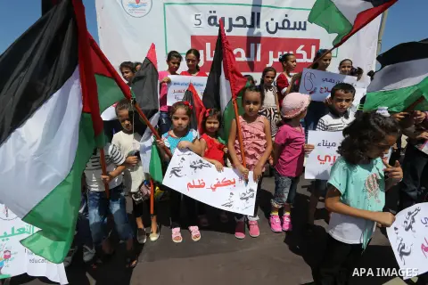 Palestinian children hold banners during a protest to break Israel's blockade on Gaza Strip, at Gaza seaport on August 16, 2018. Photo by Ashraf Amra