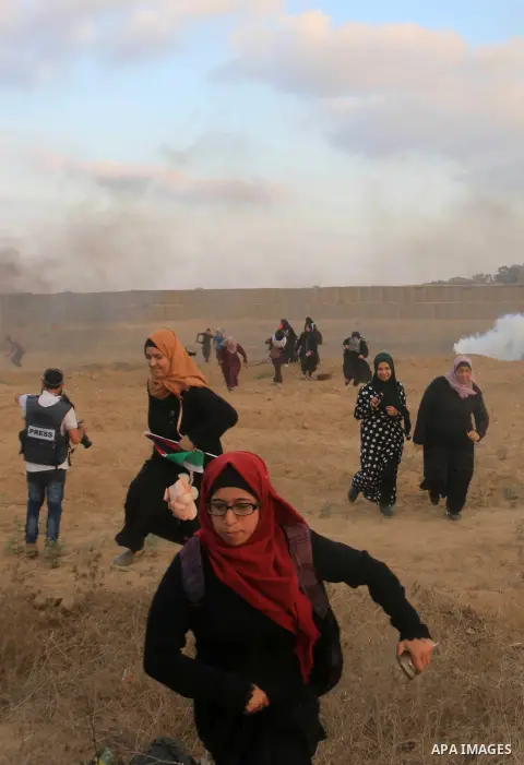 Palestinian protesters gather during clashes with Israeli troops in tents protest where Palestinians demand the right to return to their homeland at the Israel-Gaza border, in al-Bureij in the center of Gaza Strip on Aug...