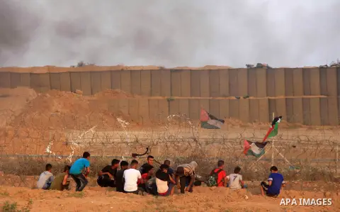 Palestinian protesters gather during clashes with Israeli troops in tents protest where Palestinians demand the right to return to their homeland at the Israel-Gaza border, in al-Bureij in the center of Gaza Strip on Aug...