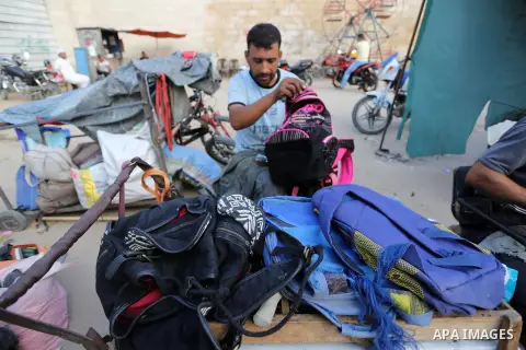 Palestinian tailors re-sewing worn out shoes and bags for students the day before the start of the new school year, at a market, in light of difficult economic and living conditions for Gazans, in Khan Younis in the sout...