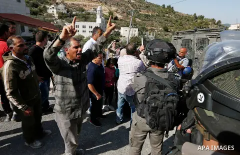 Israeli border policemen stand guard as Israeli bulldozer demolishes four houses owned by Palestinian families which Israeli authorities said it was built without a permit, in the West Bank village of Walajeh, near Bethl...