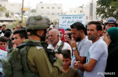 Palestinian protesters take part during a demonstration against the closure of a road since 18 years by the Israeli army in the West Bank village of Khirbat Qalqas, south of Hebron, on September 7, 2018. Photo by Wisam H...