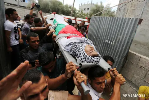 Mourners carry the body of Palestinian Belal Khafaja, 17, who was shot dead by Israeli troops during clashes in tents protest at the Israel-Gaza border, during his funeral in Rafah in the southern Gaza Strip on September...