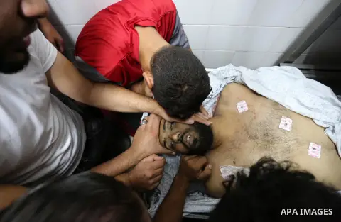 Relatives of Palestinian Hani Affana, 21, who was shot dead by Israeli troops during clashes in tents protest at the Israel-Gaza border, mourn next to his body at a morgue in a hospital, in Khan Younis in the southern Ga...
