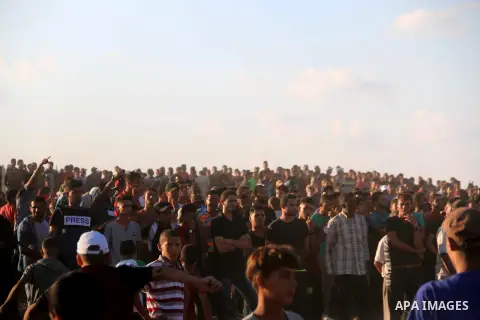 Palestinian protesters gather during clashes with Israeli troops in tents protest where Palestinians demand the right to return to their homeland at the Israel-Gaza border, in al-Bureij in the center of Gaza Strip on Sep...