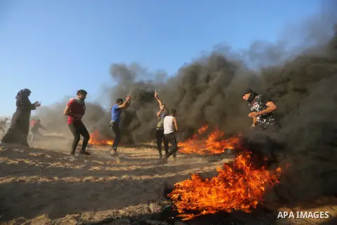Palestinian protesters gather during clashes with Israeli troops in tents protest where Palestinians demand the right to return to their homeland at the Israel-Gaza border, in Khan Younis in the southern Gaza Strip on Se...