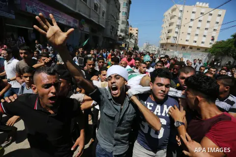 Mourners carry the body of Palestinian Mohammed Shaqoura, 21, who was shot dead by Israeli troops during clashes in tents protest at the Israel-Gaza border, during his funeral in al-Maghazi in the center of Gaza Strip on...