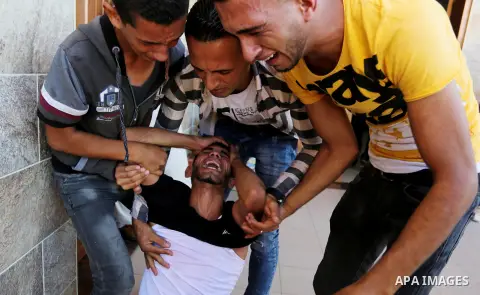 Relatives of two Palestinian men, who were killed in an Israeli air strike at the Israel-Gaza border the night before, mourns outside the hospital, after identifying the bodies in Khan Younis in the southern Gaza Strip o...