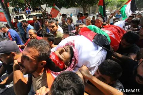 Mourners carry the body of Palestinian Mohamed Abu Nagy who was shot dead by Israeli troops during a demonstration against Israeli blockade on Gaza Strip, at the Erez crossing with Israel during his funeral in Jabalia in...