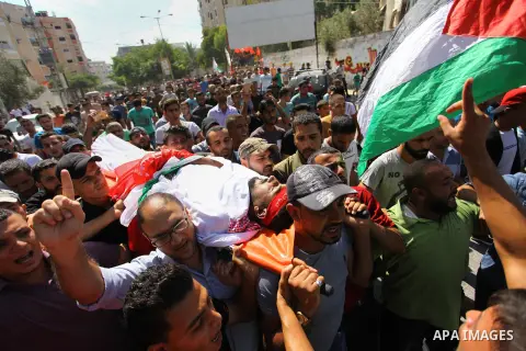 Mourners carry the body of Palestinian Mohamed Abu Nagy who was shot dead by Israeli troops during a demonstration against Israeli blockade on Gaza Strip, at the Erez crossing with Israel during his funeral in Jabalia in...