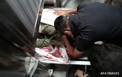 Palestinians look to the body of Emad Ashtawi, 21, who was shot dead by Israeli forces during clashes in tents protest at the Israel-Gaza border, in al-shifa hospital in Gaza City on September 23, 2018. Photo by Mahmoud...