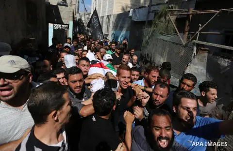 Mourners carry the body of Palestinian Mohamed Abu Sadek, 21, who was shot dead by Israeli forces during clashes at the Israel-Gaza border, during his funeral in Gaza City on September 25, 2018. Photo by Ashraf Amra
