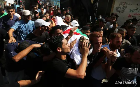 Mourners carry the body of Palestinian Mohamed Abu Sadek, 21, who was shot dead by Israeli forces during clashes at the Israel-Gaza border, during his funeral in Gaza City on September 25, 2018. Photo by Ashraf Amra