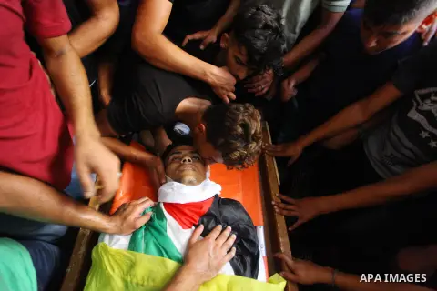 Relatives of Palestinian Iyad al-Shaer who was shot dead by Israeli forces during clashes in tents protest where Palestinians demand the right to return to their homeland at the Israel-Gaza border, mourn over his body du...