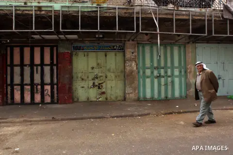 A Palestinian man walks past closed shops during a general strike against Israel's Nation State Law, in the West Bank city of Hebron on October 1, 2018. The recently-passed Israel's Nation State Law, declares that only J...