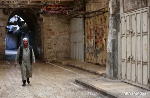 A Palestinian man walks past closed shops during a general strike against Israel's Nation State Law, in the West Bank city of Nablus on October 1, 2018. The recently-passed Israel's Nation State Law, declares that only J...