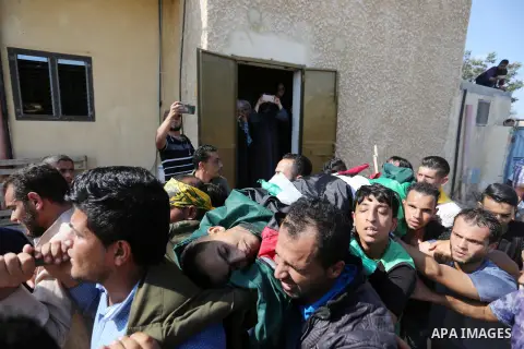 Mourners carry the body of Palestinian Abdullah Dagma, 25, who was shot dead by Israeli troops during clashes in tents protest where Palestinian demand rights to return to their homeland at Israel-Gaza border, during his...