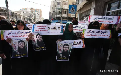 Palestinians hold posters of Islamic Jihad member Khader Adnan, who is in hunger strike at Israeli jails, during a protest calling for the release him, in Gaza city on October 16, 2018. Photo by Mahmoud Ajjour