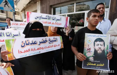 Palestinians hold posters of Islamic Jihad member Khader Adnan, who is in hunger strike at Israeli jails, during a protest calling for the release him, in Gaza city on October 16, 2018. Photo by Mahmoud Ajjour