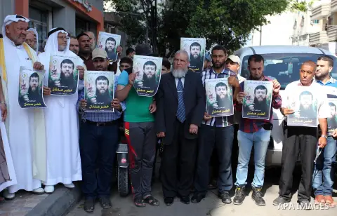 Palestinians hold posters of Islamic Jihad member Khader Adnan, who is in hunger strike at Israeli jails, during a protest calling for the release him, in Gaza city on October 16, 2018. Photo by Mahmoud Ajjour