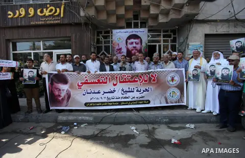 Palestinians hold posters of Islamic Jihad member Khader Adnan, who is in hunger strike at Israeli jails, during a protest calling for the release him, in Gaza city on October 16, 2018. Photo by Mahmoud Ajjour
