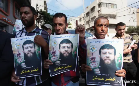 Palestinians hold posters of Islamic Jihad member Khader Adnan, who is in hunger strike at Israeli jails, during a protest calling for the release him, in Gaza city on October 16, 2018. Photo by Mahmoud Ajjour