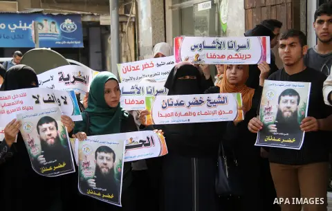 Palestinians hold posters of Islamic Jihad member Khader Adnan, who is in hunger strike at Israeli jails, during a protest calling for the release him, in Gaza city on October 16, 2018. Photo by Mahmoud Ajjour