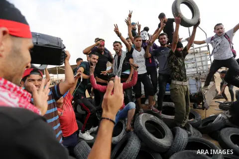 Palestinian protesters collect tires before burning it at Israel-Gaza border during a protest where Palestinians demand rights to return to their homeland, in Khan Younis in the southern Gaza Strip October 19, 2018. Phot...