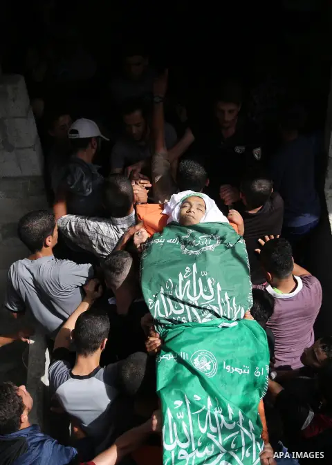 Mourners carry the body of Palestinian Muntaser al-Baz, who was shot dead by Israeli forces during a protest at the Israel-Gaza border, during his funeral in Dair Al Balah in the central Gaza Strip, on October 24, 2018....